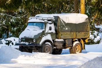 Old army military troop transport truck in a winter forest