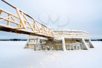 Ice and snow covered metal constructions of floodgate and dam. Extremely Cold Weather