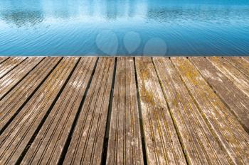 The texture of the boards of the old rustic wooden jetty on a tranquil lake . Abstract background and texture for design ideas.
