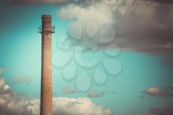 Factory chimney against the dramatic sky background. Global Warming.