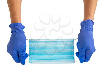 Hand holds a medical face mask against viruses and bacteria. Isolated on a white background.Protective medical tools.