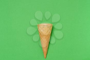 Sweet wafer cone on green background
