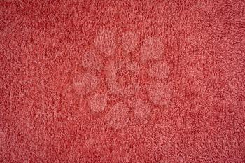 Red plush bath towel fabric. Red fabric and texture concept - close up of a towel terry cloth 