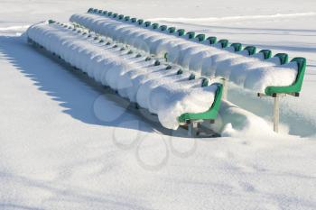 Seats of stadium in a deep snow after a strong snowfall