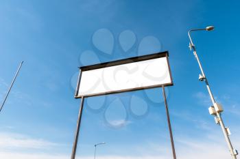White empty billboard from low angle on sky background