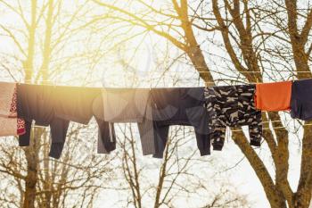 Rope with clean clothes outdoors on laundry day. Colorful clean laundry clothes, towels drying in sun washing line.