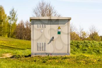 Outdoor electric high voltage distribution cabinet on a sunny spring day