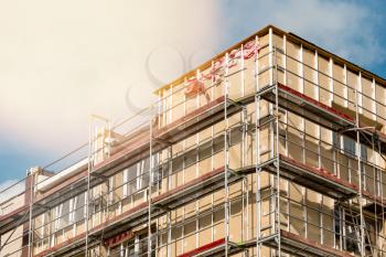 Renovation of the facade of a multistorey building.Scaffolding standing against the wall of multistorey building.