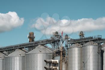 Silver silos on agro-processing and manufacturing plant for processing drying cleaning and storage of agricultural products, flour, cereals and grain. 