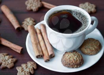 Coffe caup with cinnamon sticks and cookies