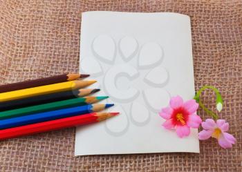 Photo card on sack materail with colorful pencils and flowers