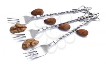 Dessert forks with almonds and walnuts isolated on white