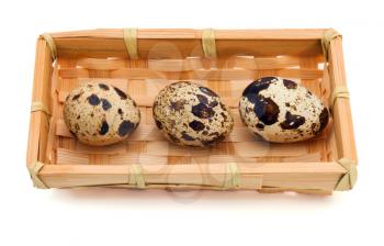 Quail eggs in basket over white background