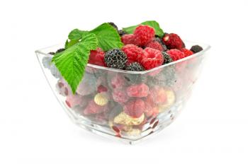 Red and white strawberries, raspberries, and blackberries in a glass isolated on white background