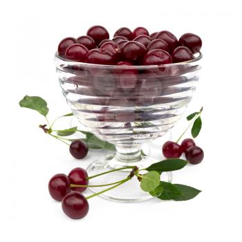 Cherry in a glass bowl on the table with green leaves isolated on white background