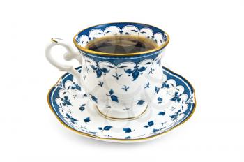 Coffee in a porcelain cup with a blue pattern is isolated on a white background
