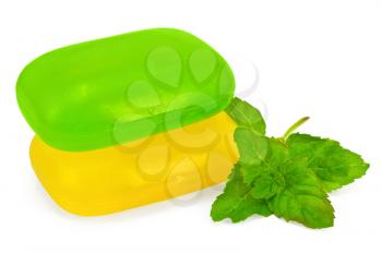 Green and yellow soap with a sprig of mint isolated on white background