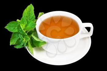 Herbal tea in a white porcelain cup with sprigs of mint isolated on black background