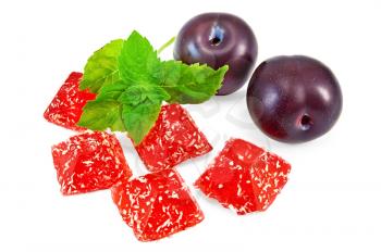Red jelly with two plums and a sprig of mint isolated on white background