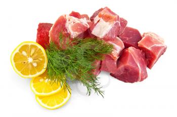 Chunks of pork with lemon and a sprig of dill is isolated on a white background