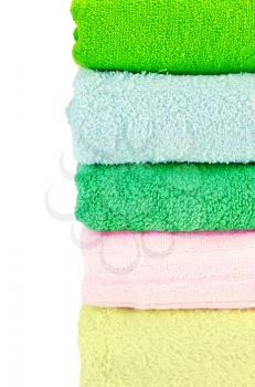 Stacked towels green, blue, pink and yellow color isolated on white background