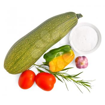 One green zucchini, two red tomatoes, one yellow bell pepper, garlic, tarragon, a dish of salt is isolated on a white background