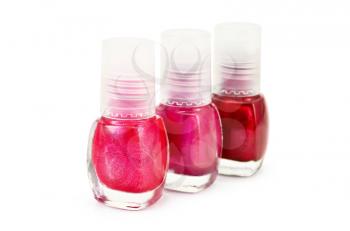 Three bottles of nail polish with different shades of red color isolated on white background