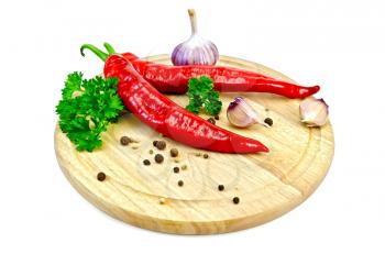 Hot red pepper, garlic, parsley, peppercorns and mustard on a circular wooden board isolated on white background