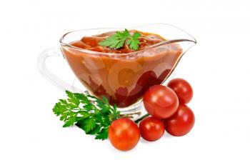 Ketchup in a glass gravy boat with tomatoes and parsley isolated on white background