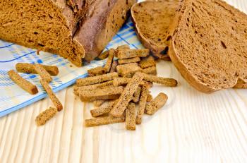 Rye homemade bread, crackers, blue cloth on a background of wooden boards