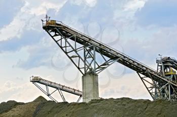 Equipment for the production of crushed stone on a background of blue sky and clouds