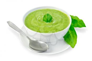 Cream soup green from spinach in a white bowl with leaf spinach on a plate, spinach leaves isolated on white background