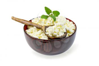 Cottage cheese in a wooden bowl with a spoon on a napkin and mint isolated on white background