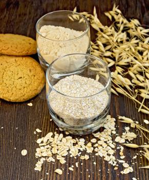 Bran small and flour oat in a two glassful, oatmeal and ears, cookies on a background of wooden boards