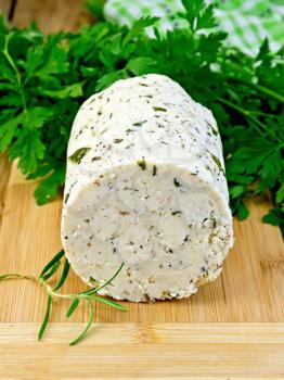 Homemade cheese with herbs and spices, parsley, rosemary and basil, napkin on a background of wooden boards