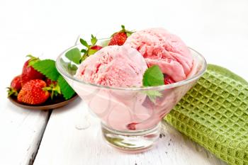 Ice cream strawberry in a glass with berries and mint, napkin on a wooden board background
