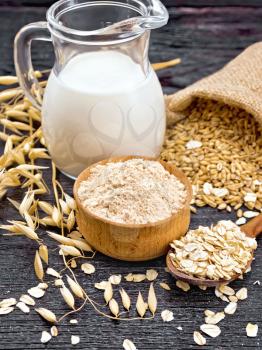 Flour oat in bowl, grain in a bag, oatmeal in a spoon, oaten stalks on the background of wooden board