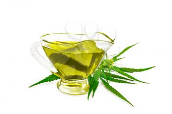 Hemp oil in a sauceboat, cannabis leaves and stalks isolated on white background