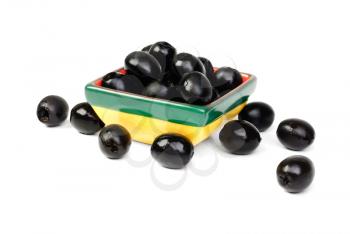 Black pitted olives in ceramic salad bowl isolated on white macro