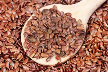 close up of flax seeds and  wooden spoon food background