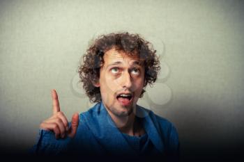 Closeup portrait of intelligent daydreaming young man who just came up with an idea aha. Positive emotion facial expression feeling, attitude, perception, body language