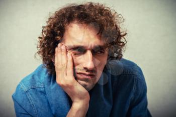 curly-haired man leaned his chin on hand