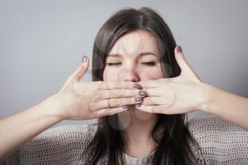 girl covers her mouth with her hands