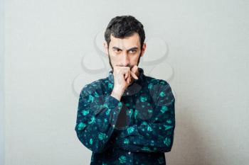 Closeup portrait of young man thinking daydreaming deeply about something with chin on hand fist looking downwards. Emotion facial expressions feelings