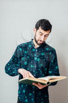 Young hipster man reading a book