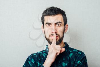 Young hipster man making silence gesture