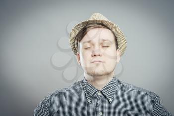 Young relaxed man in hat closed his eyes and dreams
