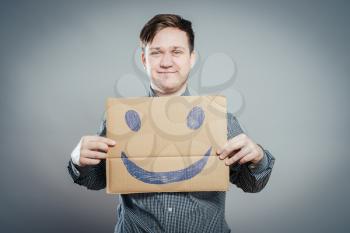 Man with the painted happy smile on the sheet of paper