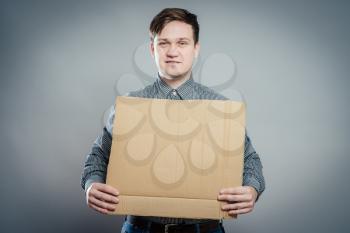 young man showing empty board