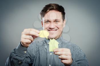 Closeup portrait of young man with a piece of paper home and dialogue  on gray background